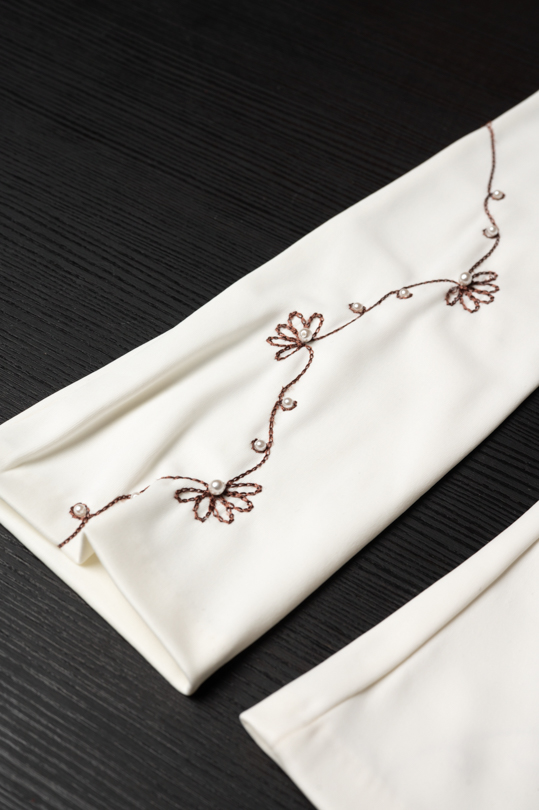 Détail de la broderie florale des gants longs en satin ivoire
