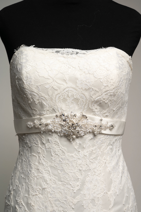 Détail de la ceinture en satin ornée de strass de la robe Clémence