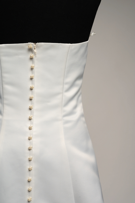 Détail des boutons perlés dans le dos de la robe de location Valentina