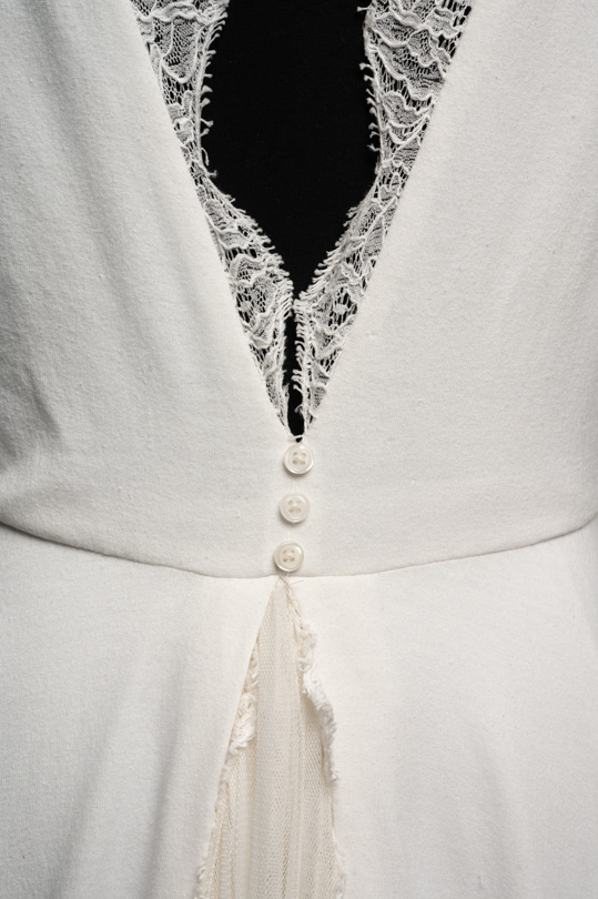Détail du dos en dentelle et maille de la robe de location Emma