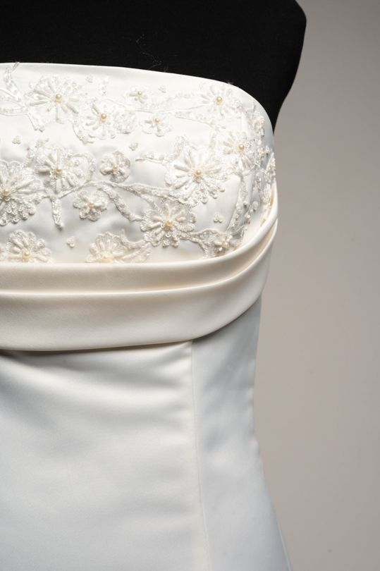 Détail de la dentelle brodée et perlée du bustier en satin de la robe Valentina