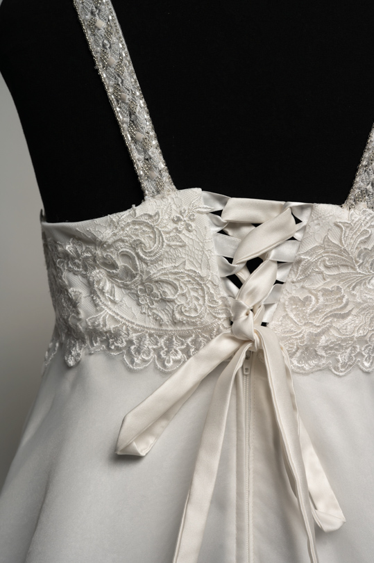 Détail du dos lacé et de la dentelle perlée de la robe de location Lya