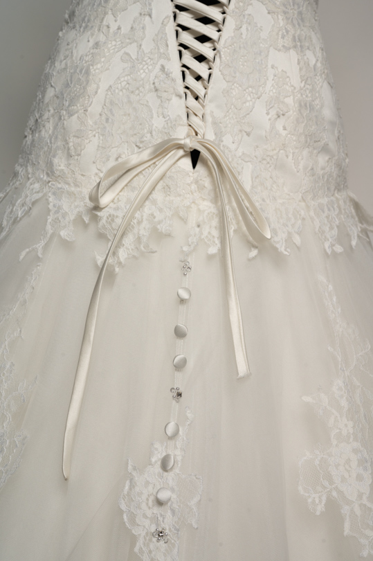 Détail des boutons à strass et du laçage dos de la robe de location Clémence